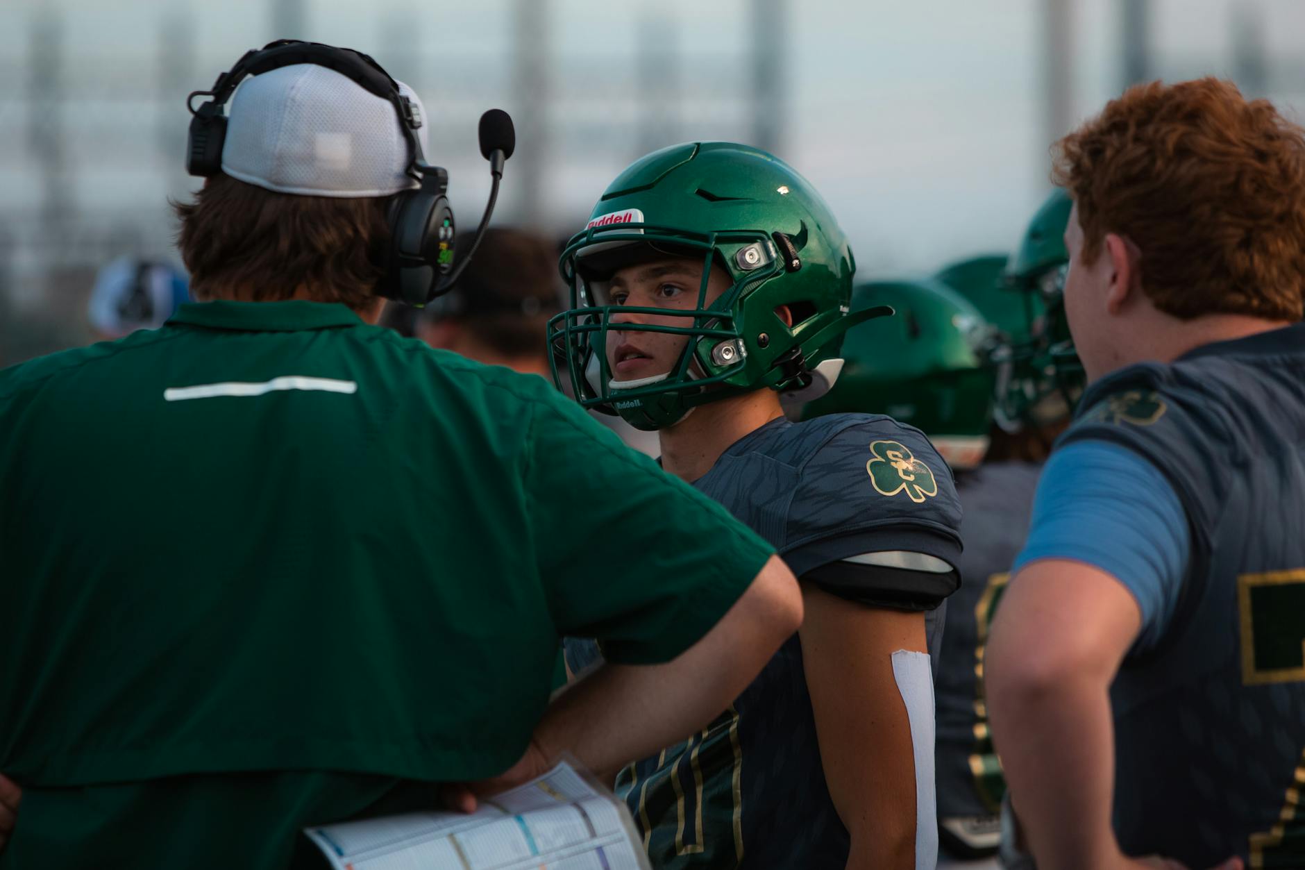 Piłkarze i trener omawiają taktykę podczas meczu na stadionie