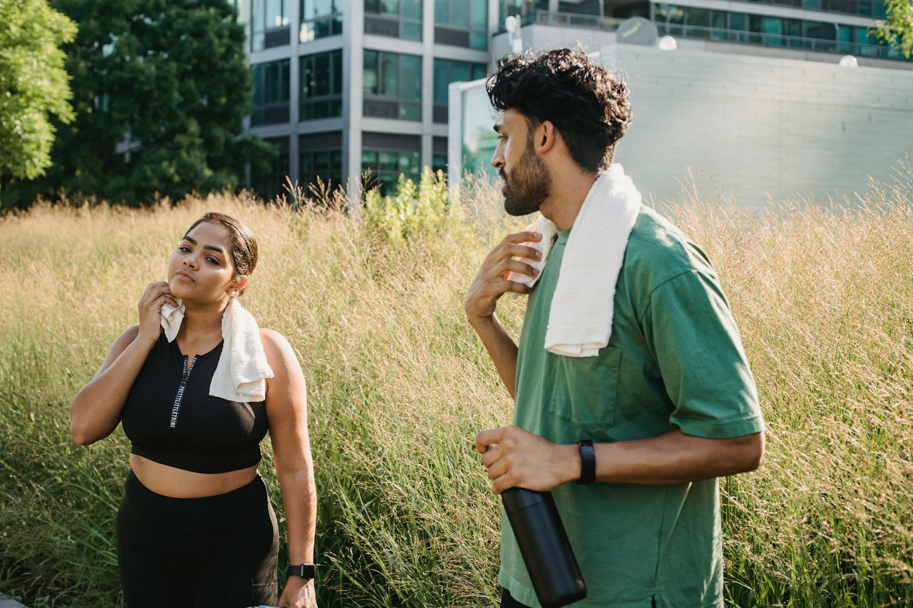 Dwóch dorosłych odpoczywa po treningu w miejskim parku latem