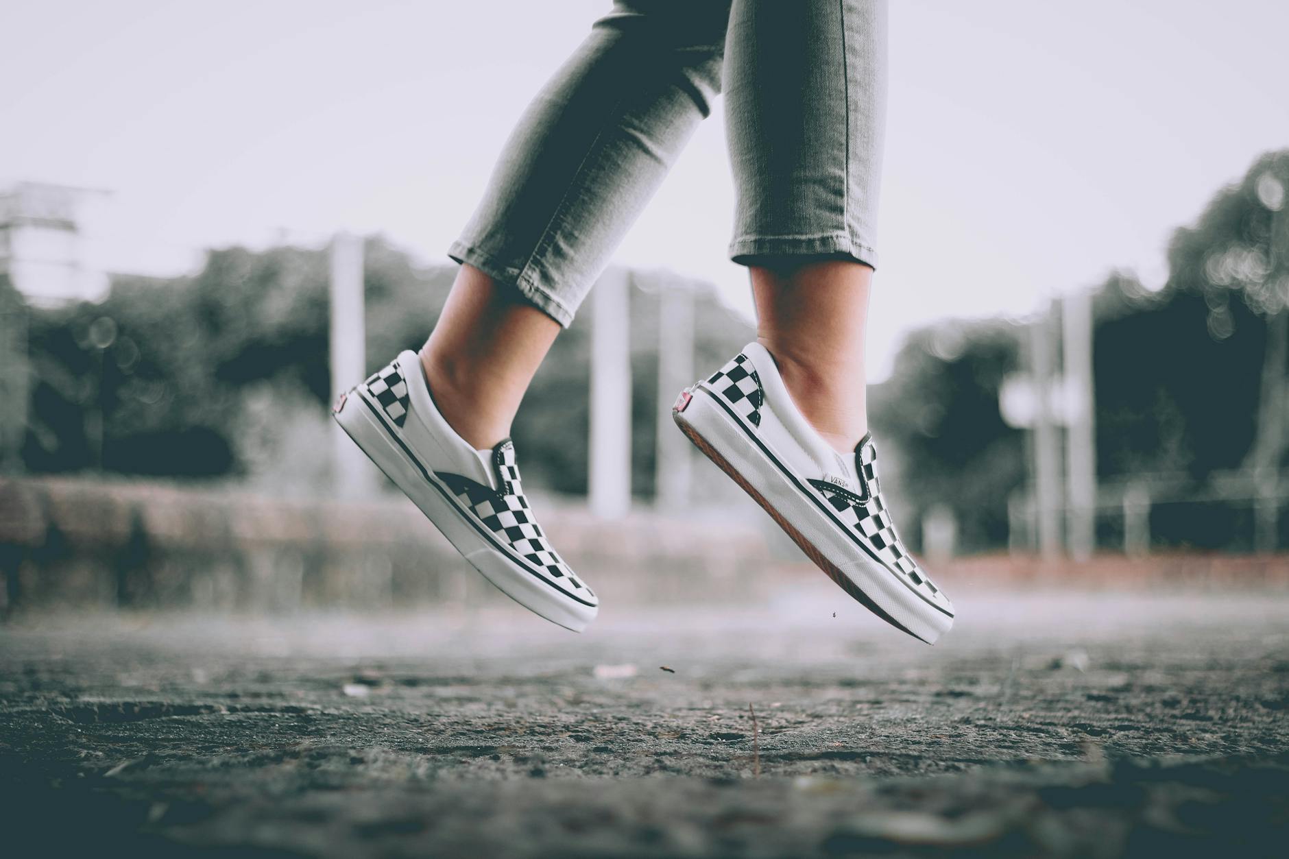 Skaczące nogi nastolatka w kratkowanych sneakersach podczas treningu