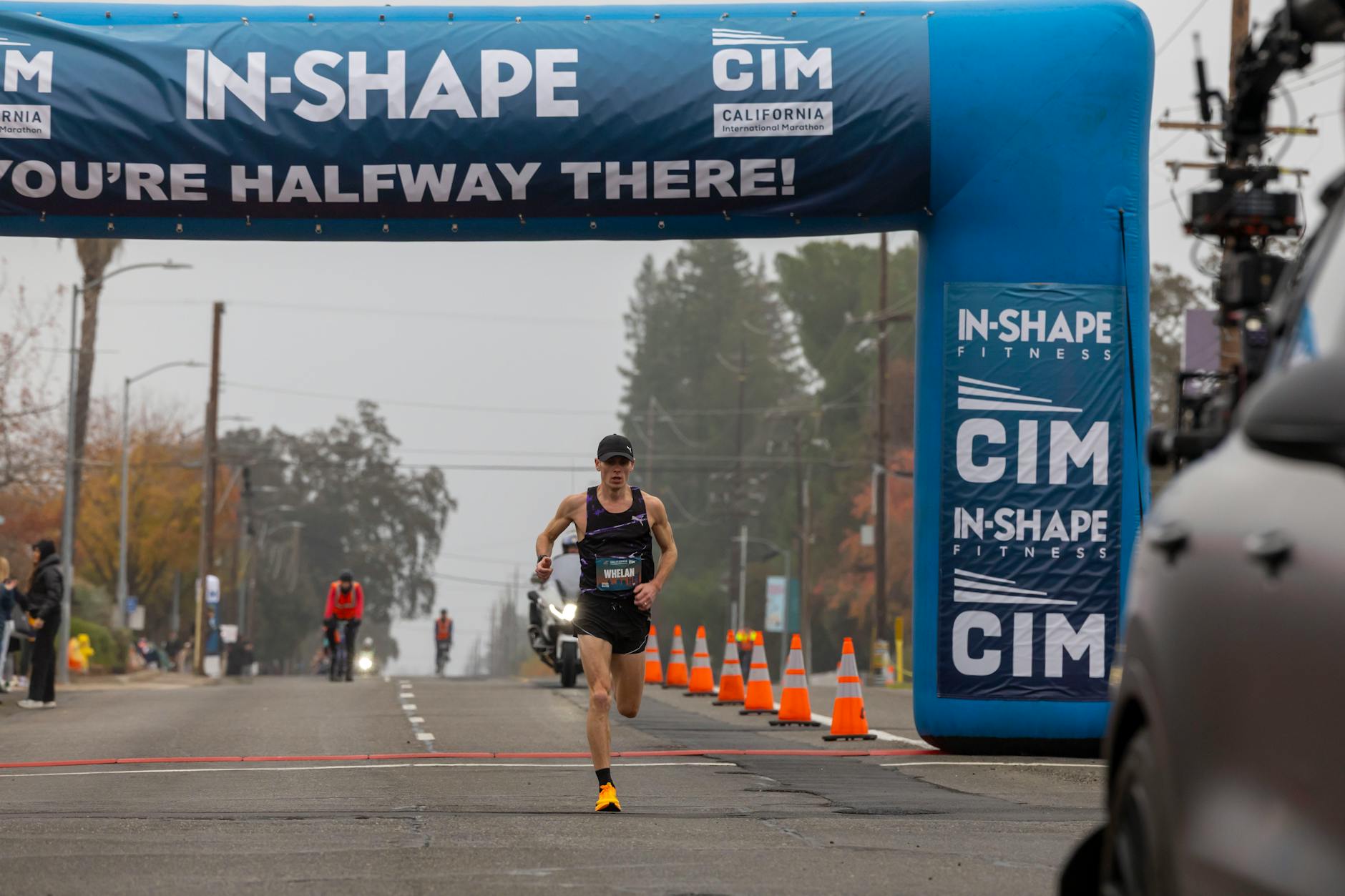 Skupiony maratończyk mija półmetek biegu ulicznego