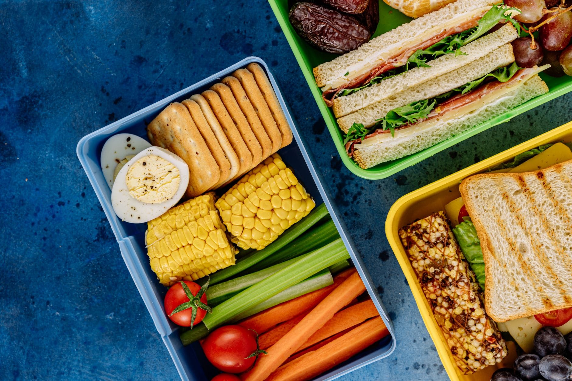 Kolorowe lunchboxy z kanapkami, warzywami i zdrowymi przekąskami
